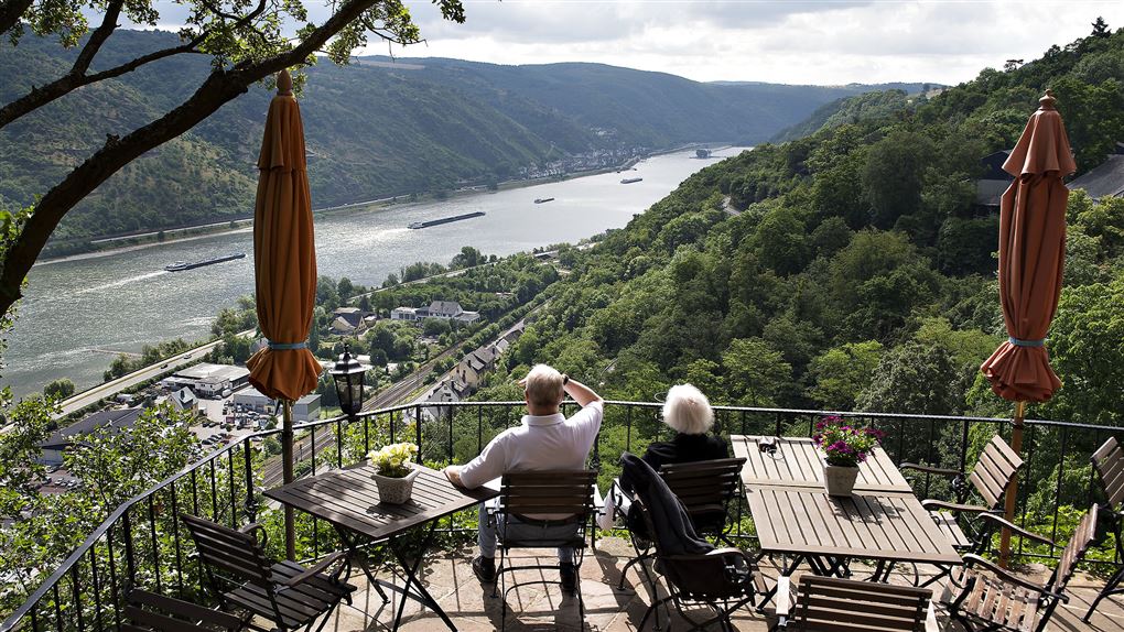 Pensionistpar kigger på Rhinen fra terrasse over Oberwesel