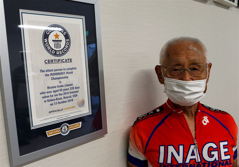 den 87-årige japanske triatlet Hiromo Inada ses foran sit diplom fra Guinness World Records som beviser at han er den ældste til at gennemføre en ironman i triatlon