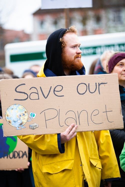 Mand med et skilt, hvor der står Save our planet