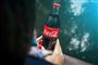 Person holder en coca cola flaske i hånden