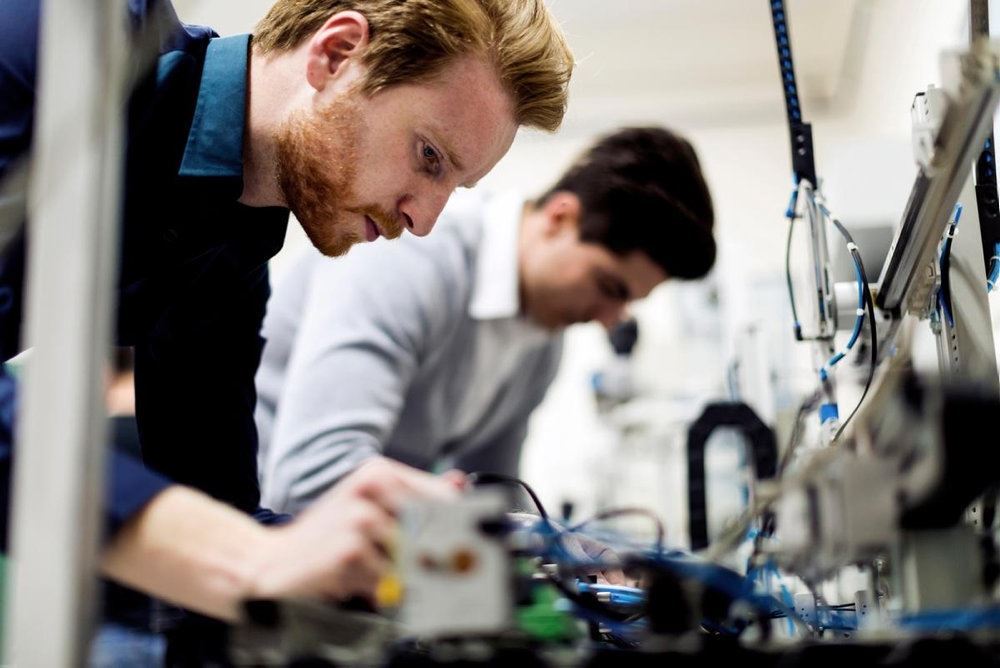 To mænd arbejder koncentreret med elektronik