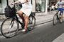 To cykler på en gade, hvor den første er en elcykel