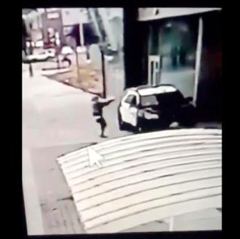 En mand skyder ind gennem en parkerte politvogns ruder