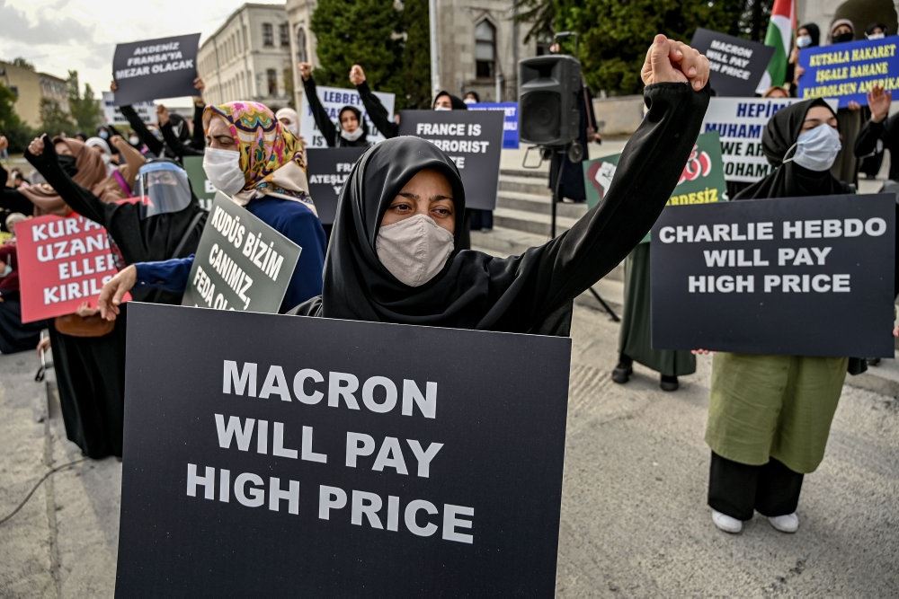 Demonstranter med bundbind. Forrest står en demonstrant med et skilt med skriften "Macron vi betale den højeste pris".