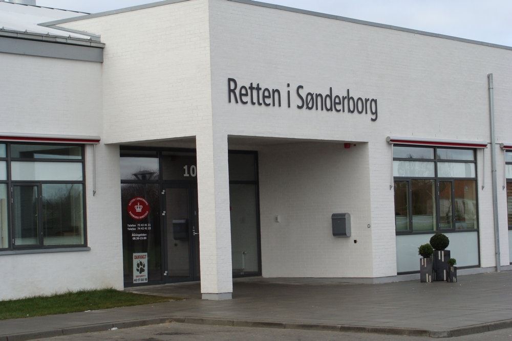 Den hvide bygning hvor retten i Sønderborg har til huse. Der står Retten i Sønderborg med store sorte bogstaver på den hvide facade.