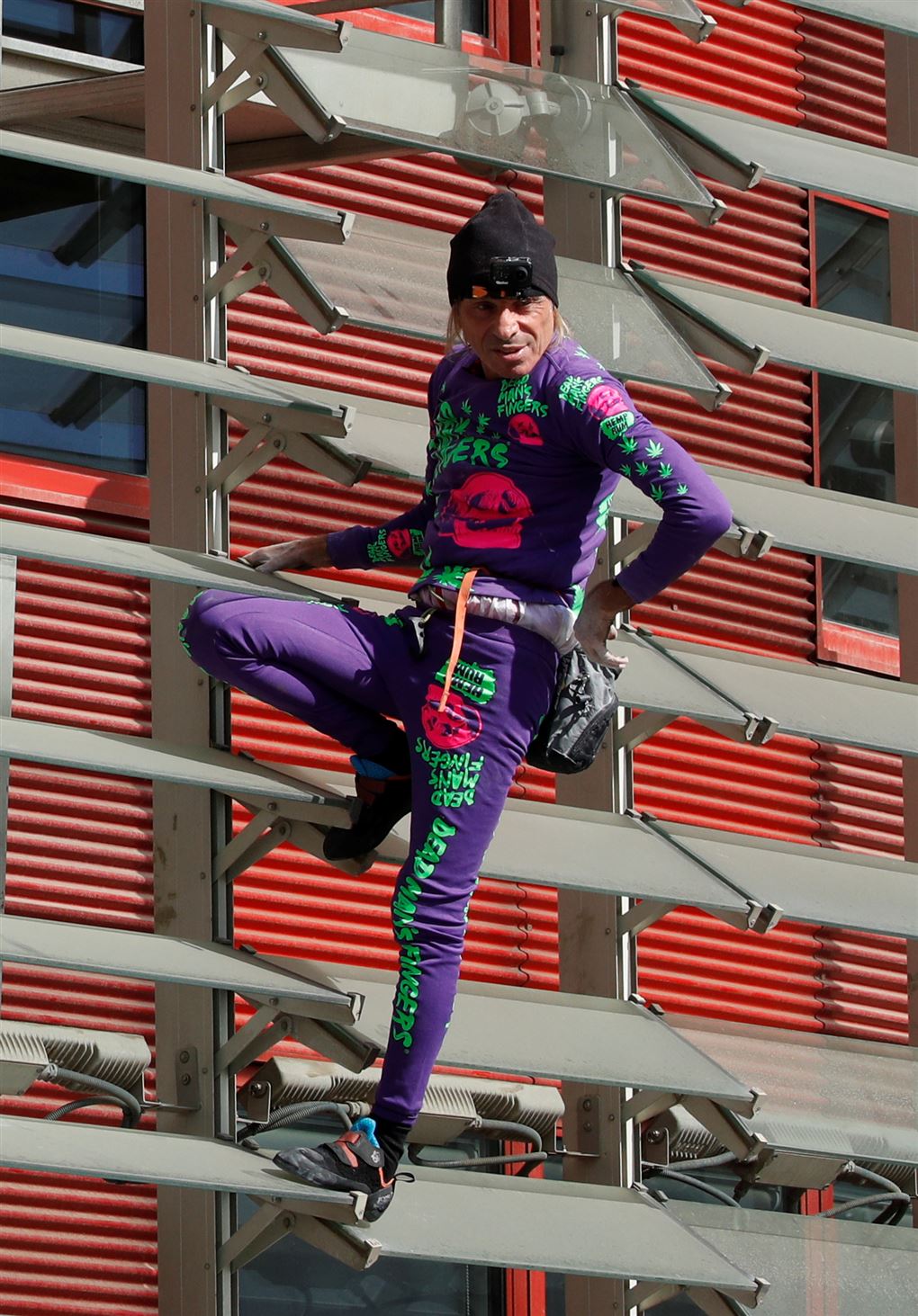 En mand på en facade i tætsiddende kravler-outfit