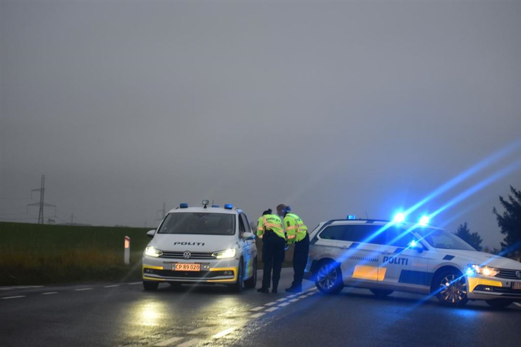 To politibiler med blink spærrer en hovedvej af.