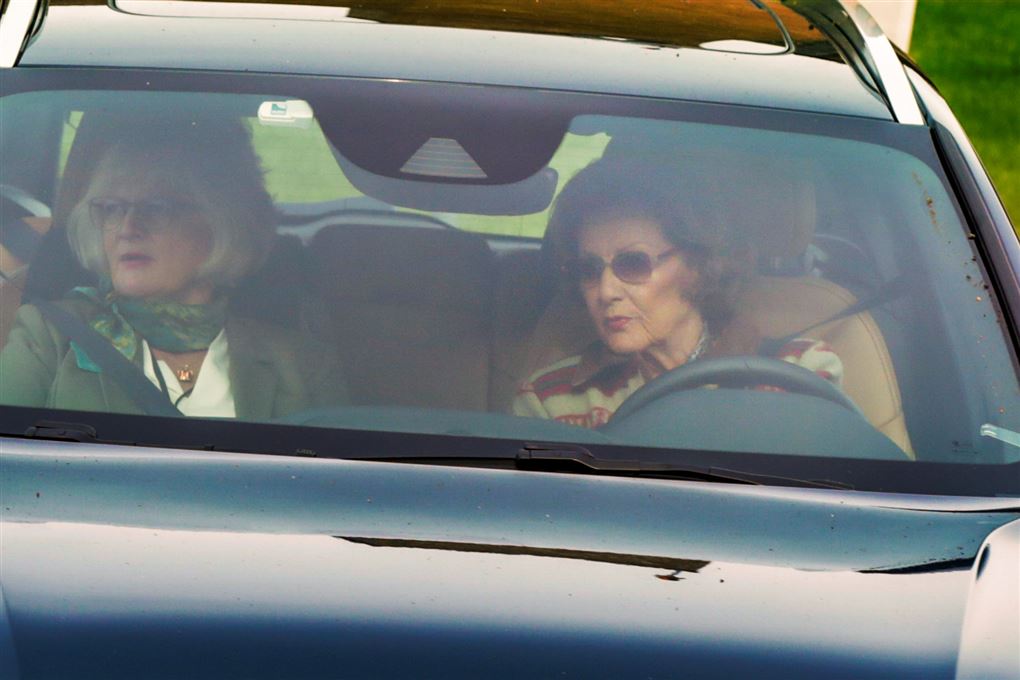 Den norske Dronning Sonja sidder bag rattet i en bil 