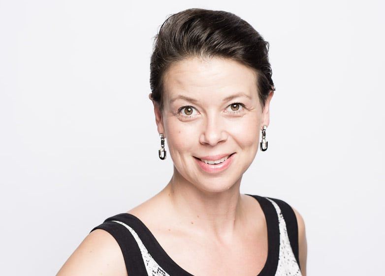 en brunnette smiler til kameraet