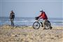 Cyklist på strand i strålende solskin