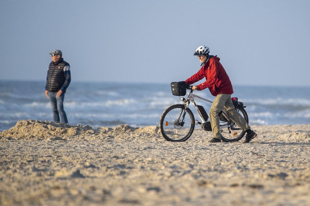 Cyklist på strand i strålende solskin