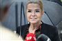 Venstres Inger Støjberg smiler mens hun står under paraply