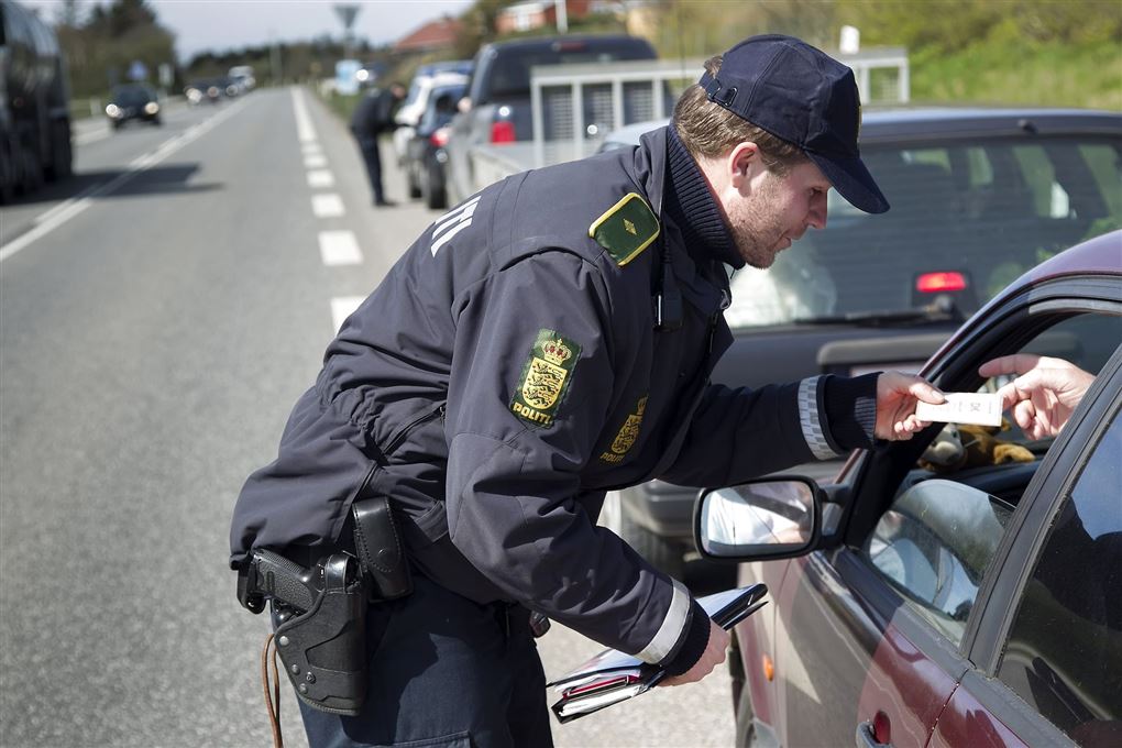 en politibetjent tjekker en bilist med alkoholmeter