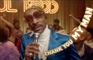 Snoop Dogg med hvis rullekrave, blå blazer og solbriller danser og synger