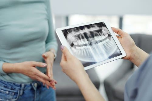 En patient kigger på et røntgenbillede af nogle tænder 