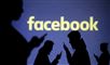 Silhoutter med mobiltelefoner og et Facebook skilt i baggrunden