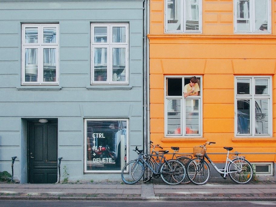 En gade i København med en unge, der kigger ud af et vindue