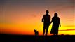 par går tur med hund i solnedgang
