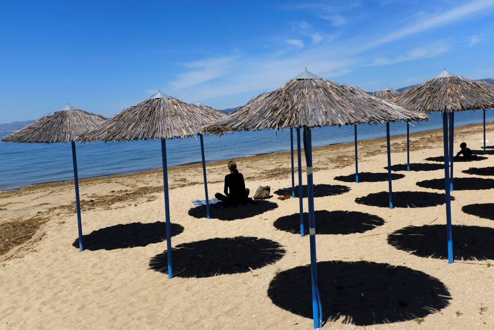 En halvtom strand med blåt hav og blå himmel