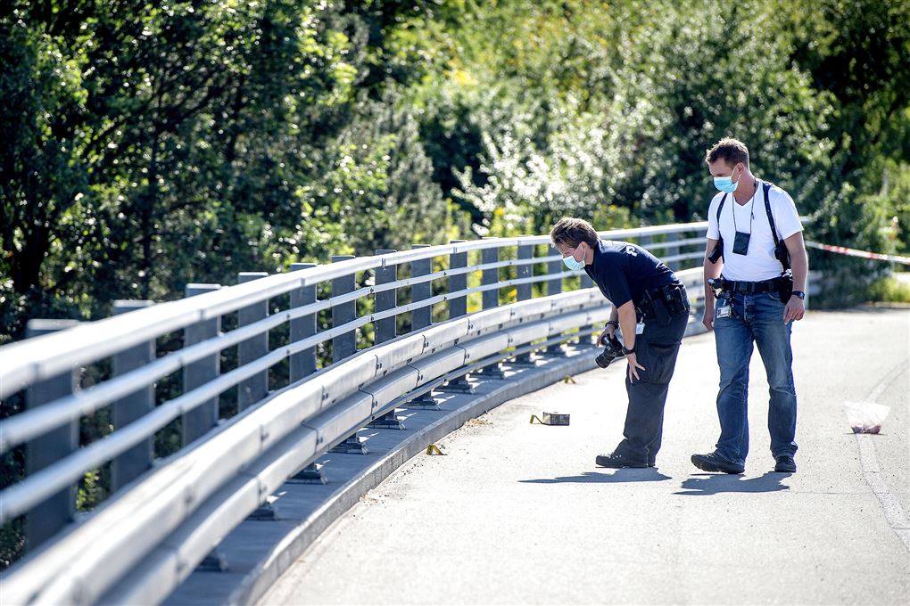 2 politibetjente med masker undersøger vejen på en bro....