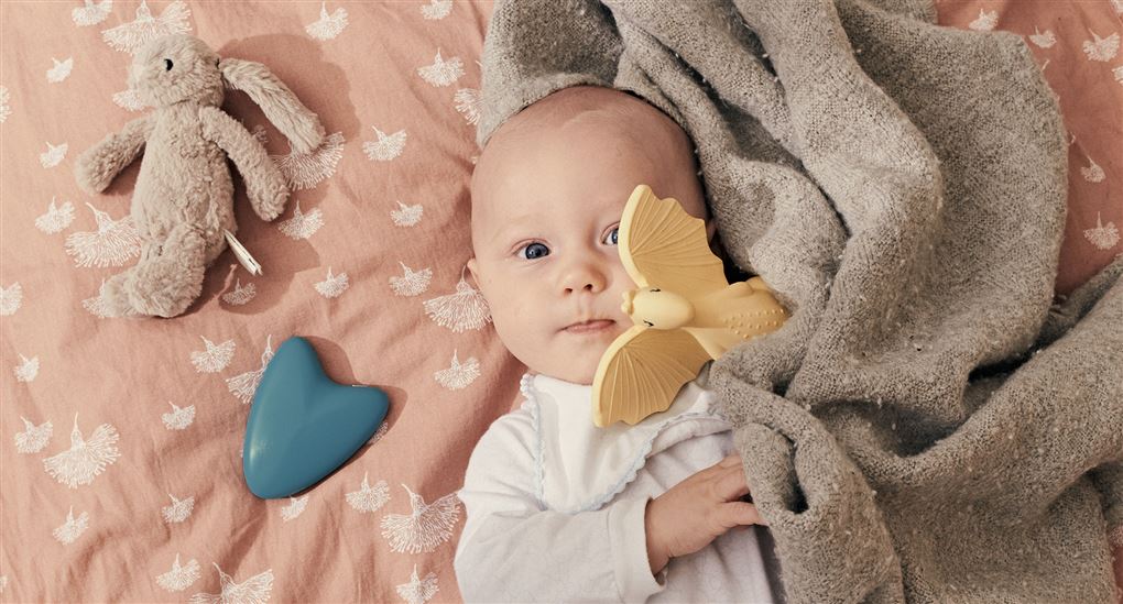 en baby med en blå elektronisk tingest ved siden af sig