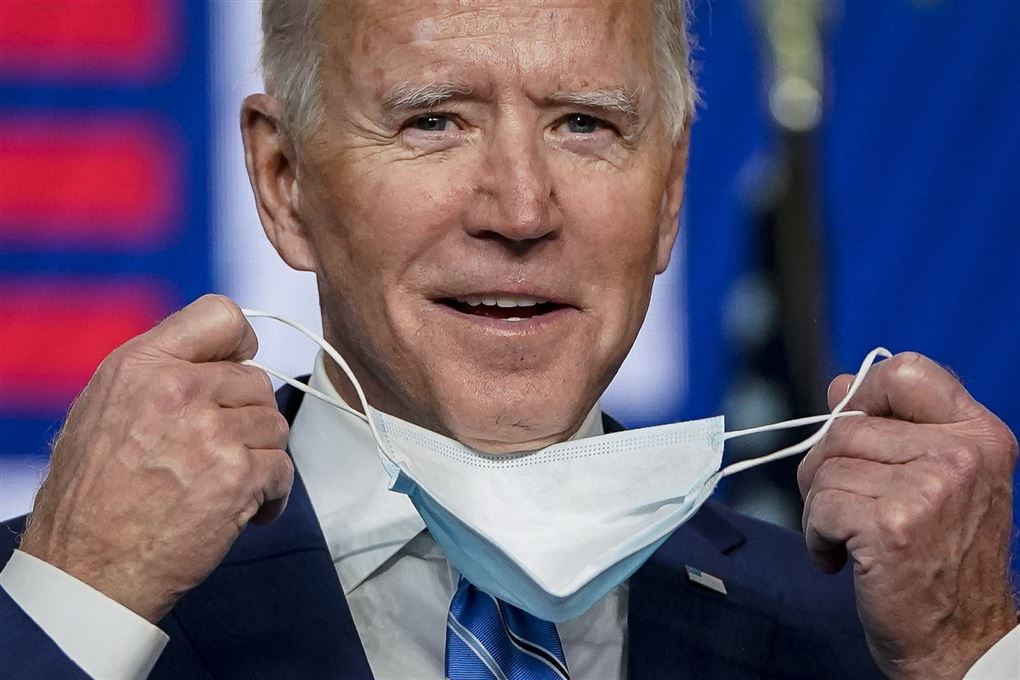 Joe Biden smiler, mens han tager sit mundbind af