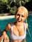 Blond kvinde med store bryster ved en swimmingpool