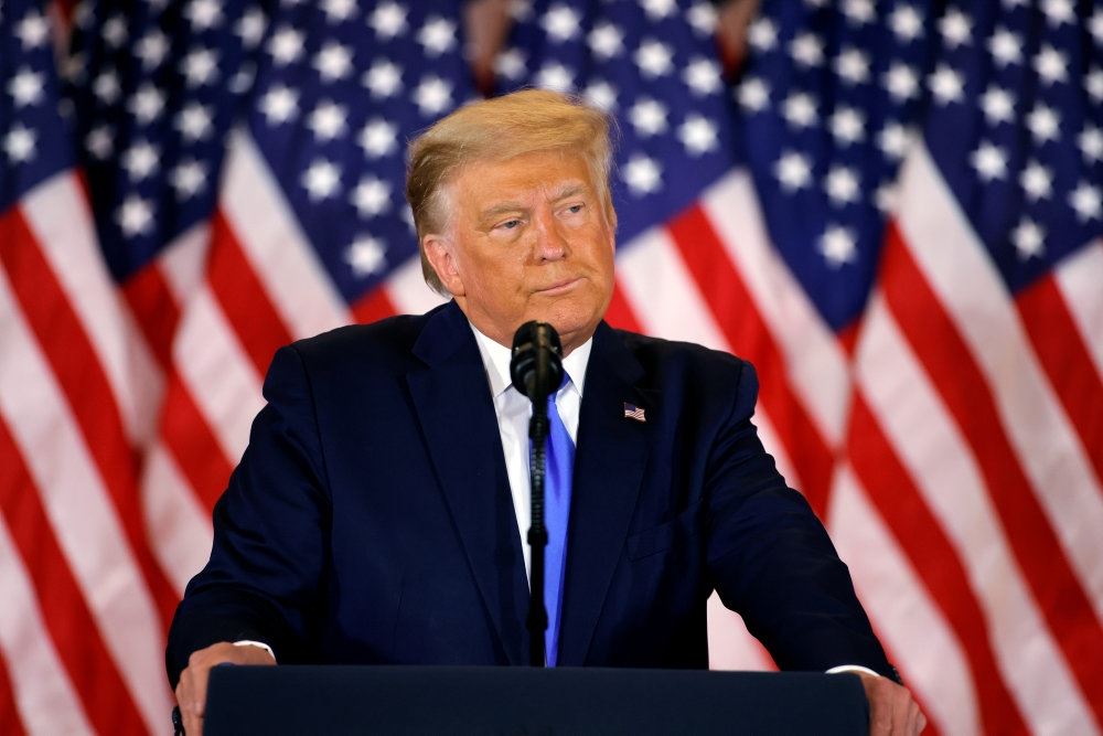 Trump på talerstol med amerikanske flag i baggrunden