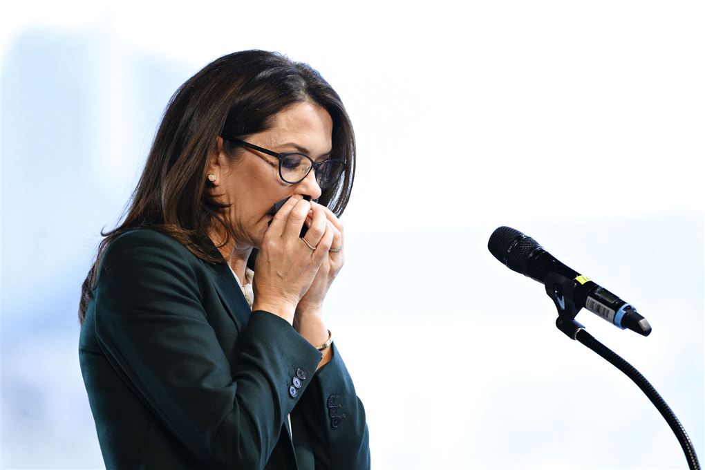 Kronprinsesse Mary tørrer næse og kigger ned på en talerstol. 