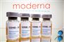 fire doser med coronavaccine foran et skilt med skriften Moderna