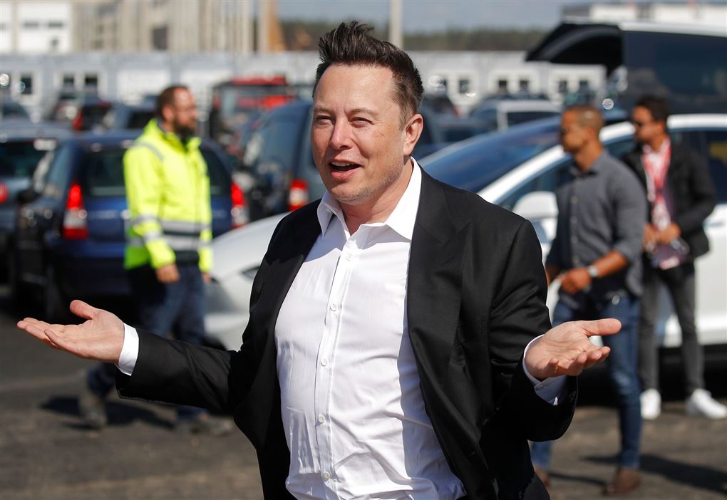Elon Musk smiler og slår ud med armene