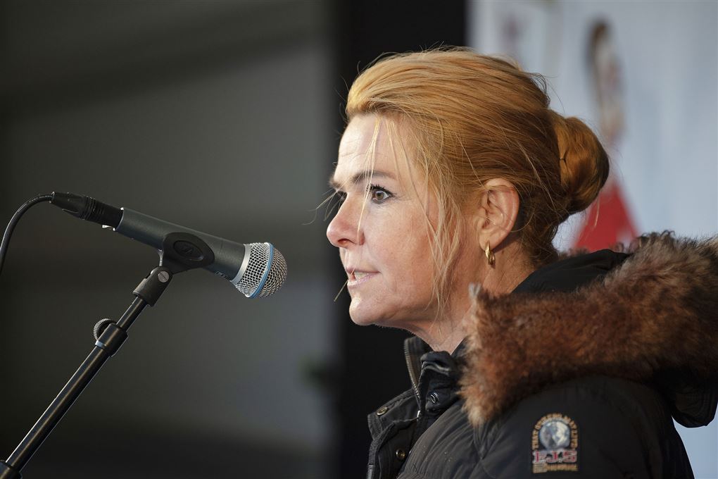 Inger Støjberg i jakke står foran mikrofon 