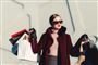 kvinde iført solbriller med indkøbsposer i hænderne