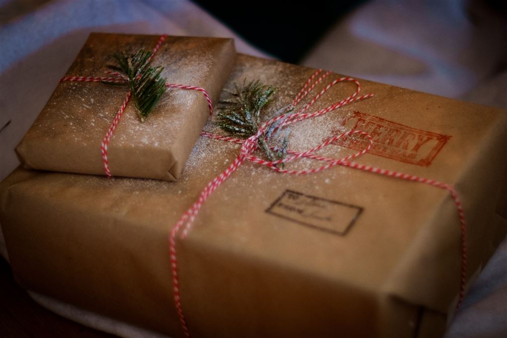 To julegaver der er pakket ind i brunt gavepapir. Den nederste har to stempler på.