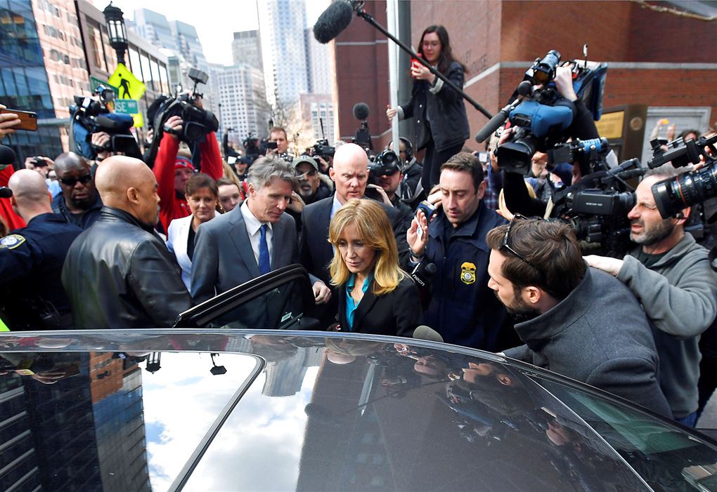 Felicity Huffman omgivet af pressefolk på vej ind i en bil