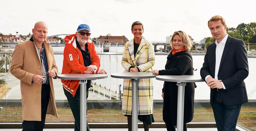 Thomas Blachman, Peter Aalbæk, Margrethe Vestager, Stine Bosse og Morten Messerschmidt står ved cafeborde ved havn