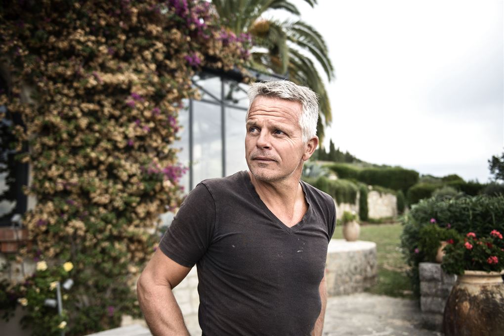 Jakob Kjeldberg foran sit hus i Sydfrankrig med en palme 