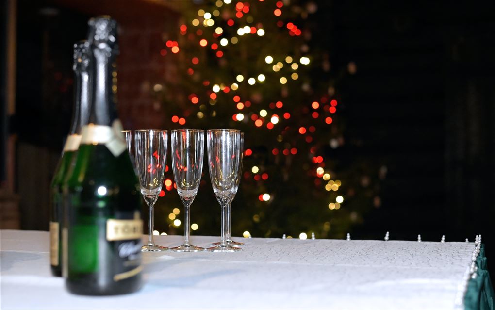 champagneflasker og glas på bord med fyrværkeri  baggrunden