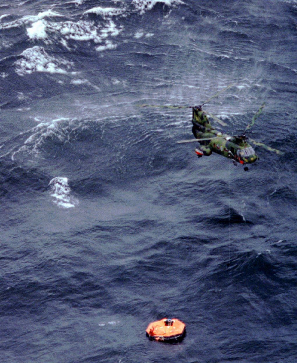 En helikopter svæver over en redningsflåde