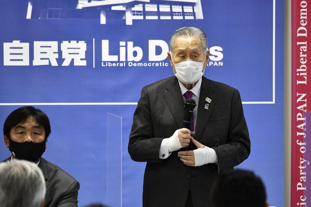 En japaner taler på en konference - med maske på