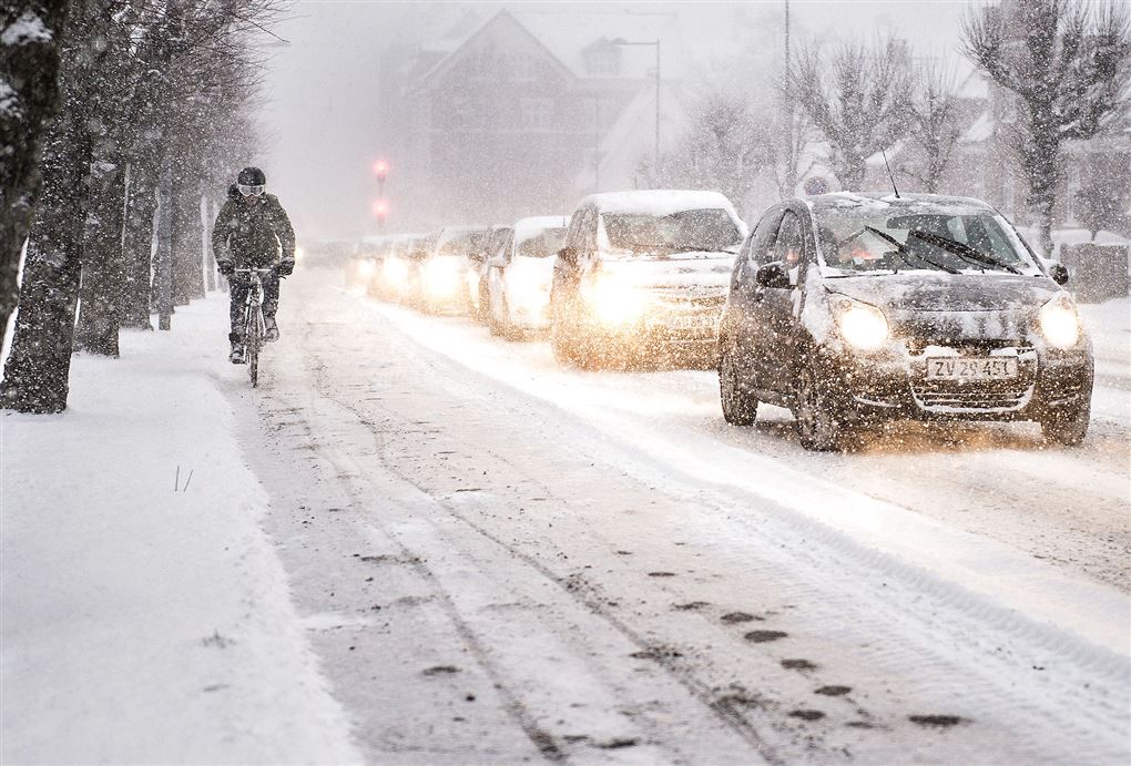 biler og cyklist kører i snevejr