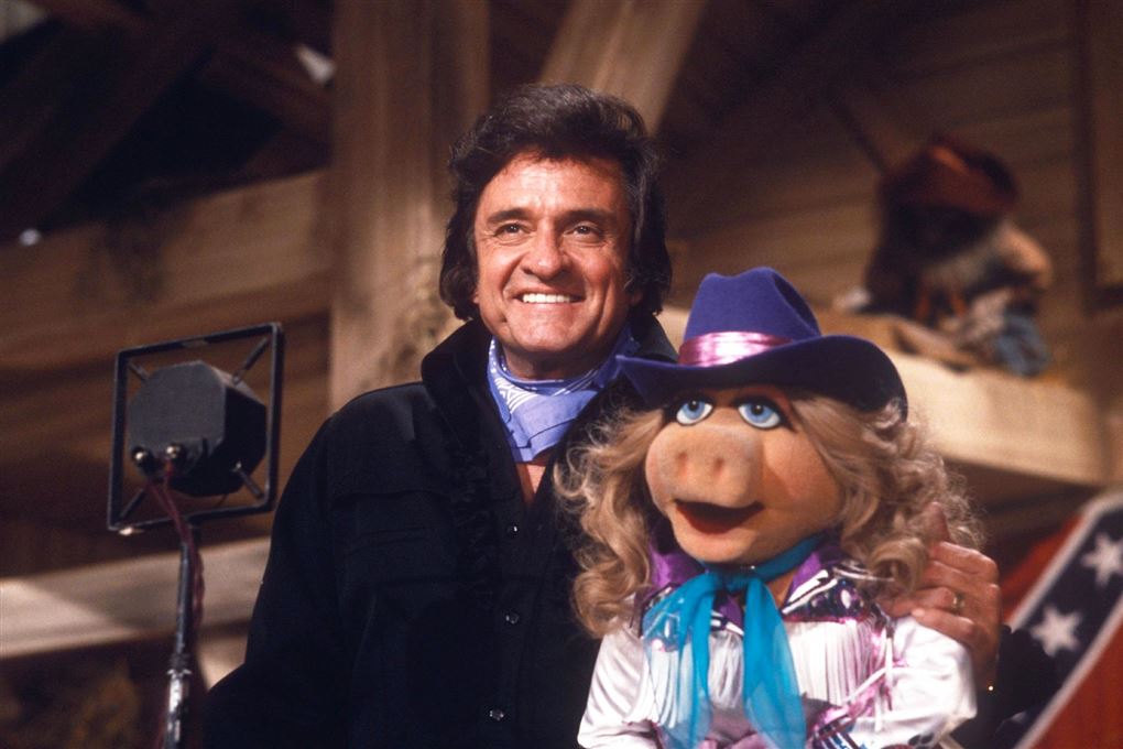 en smilende johnny cash i selskab med Miss Piggy i muppet show