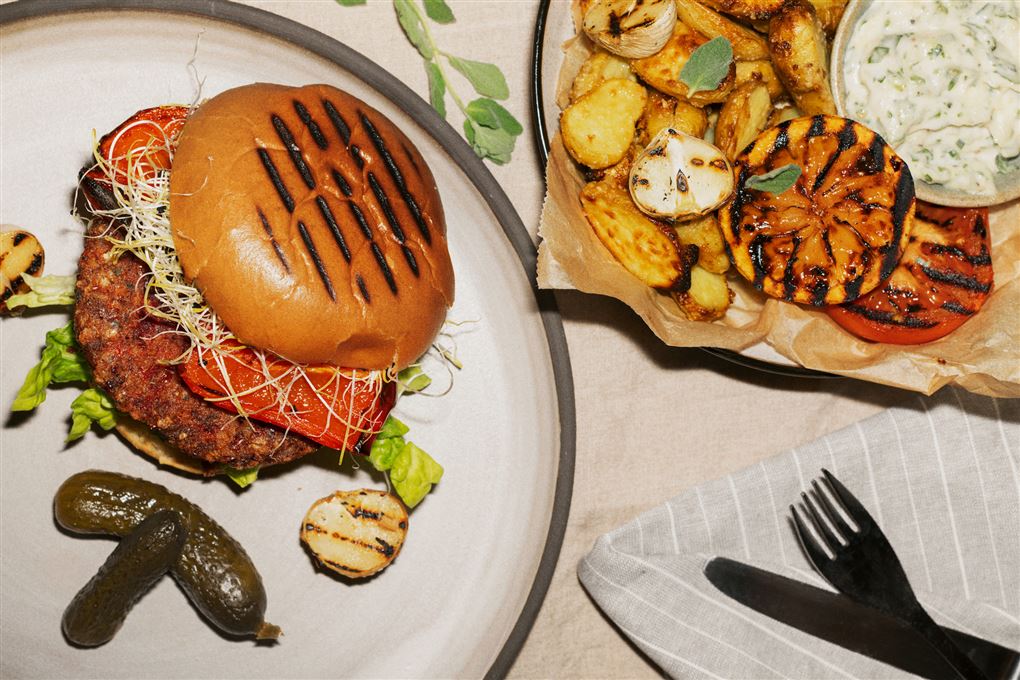 En burger på en tallerken med grønt