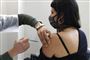 kvinde får vaccination med et stik i skulderen