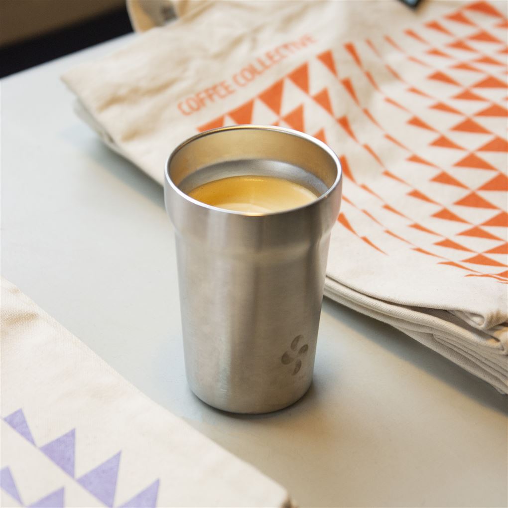En rustfri kop med kaffe i på et bord