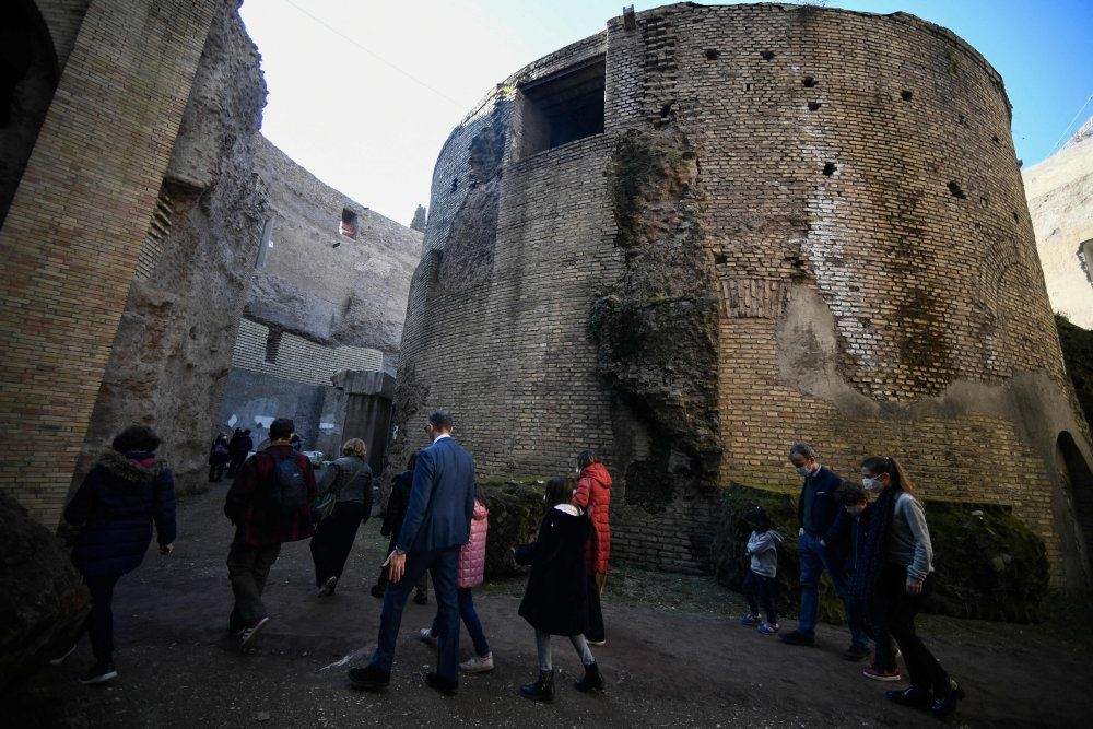 En ruinagtig bygning med menensker foran i Rom