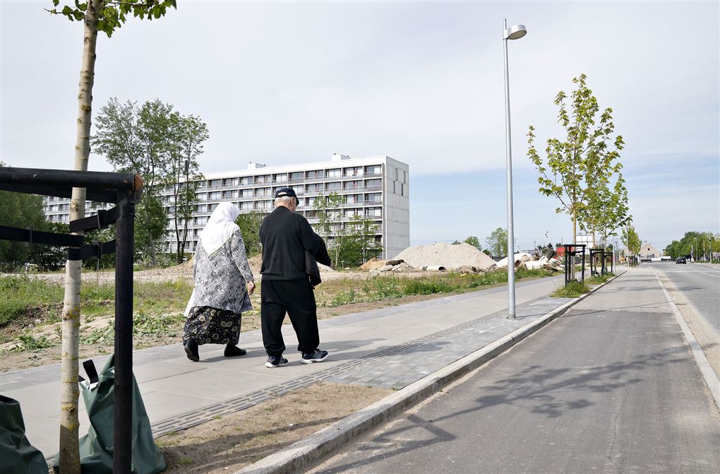 To indvandrere går med en høj bebyggelse foran dem
