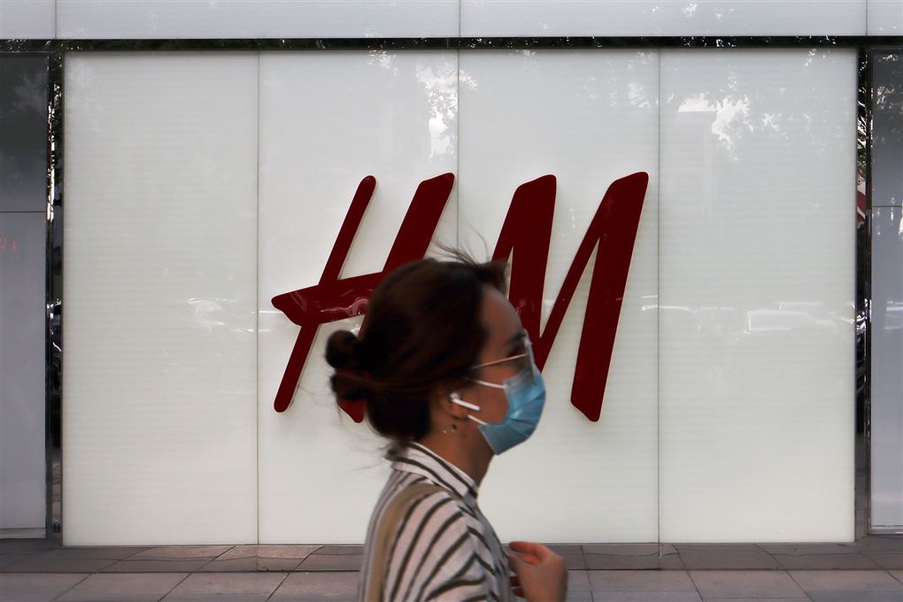 En asiatisk kvinde får forbi en H&M-facade