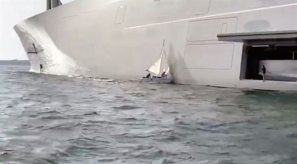 En lille båd vædrer en megayacht