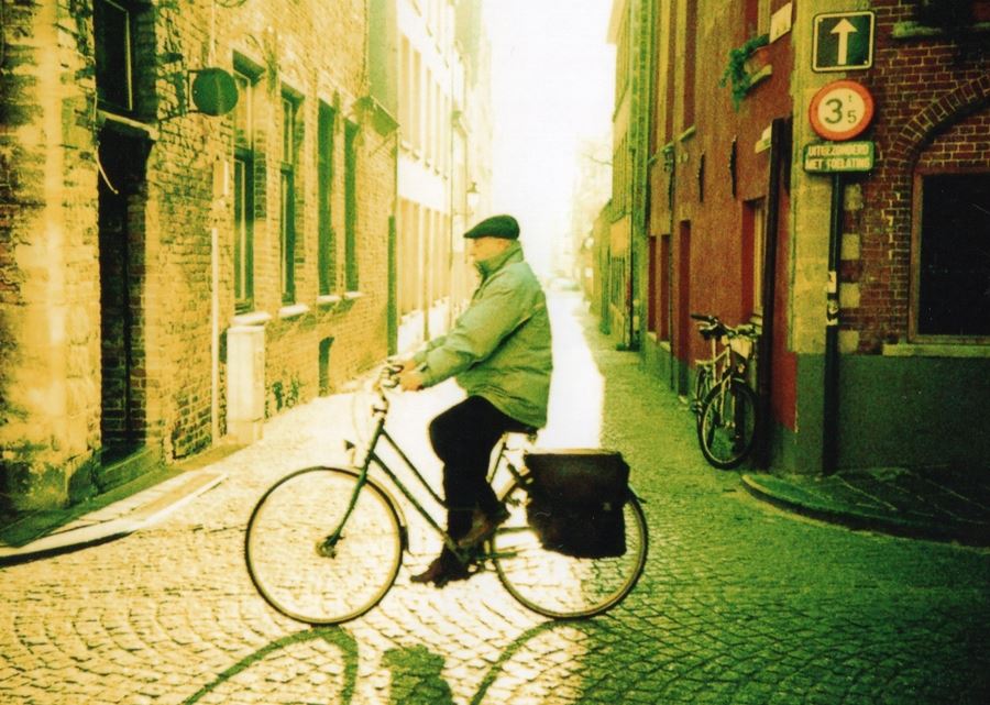 mand på cykel på brosten